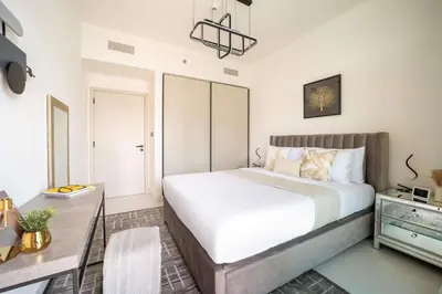 a bedroom with a large bed and a desk at Frank Porter - Marina Vista Tower 2 in Dubai
