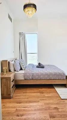 a bedroom with a large bed and a window at Luxury 2BR Carson Tower B Apt in Dubai