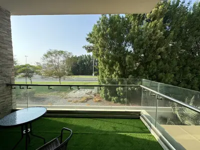 a balcony with a table and chairs and a large window at Dubai Apartment in Meydan in Dubai