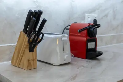 a counter top with a toaster and a toaster and knives at Lux BnB I Executive Tower I Ocean View in Dubai