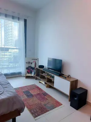a living room with a flat screen tv and a couch at Cozy Studio in JVC in Dubai