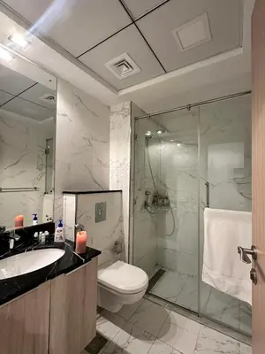 a bathroom with a toilet and a sink and a shower at Cozy Studio in JVC in Dubai