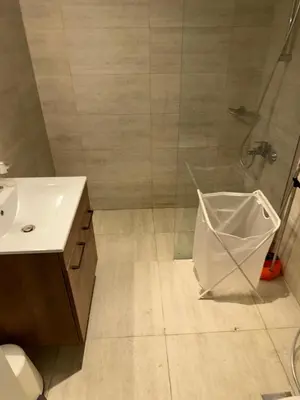 a bathroom with a shower and a toilet and a sink at Nice 1BR in Dubai