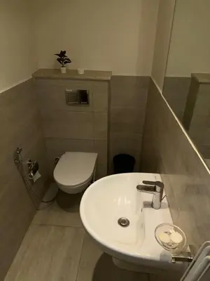 a bathroom with a white sink and a toilet at Nice 1BR in Dubai