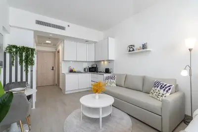 a living room with a couch and a table at Bright & Airy Studio in JVC in Dubai