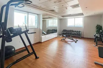 a gym with exercise equipment in a room with wood floors at Newly Furnished Unit in Elite, Business Bay in Dubai