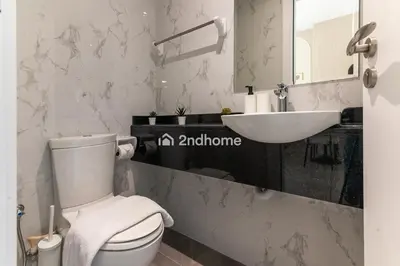 a bathroom with a white toilet and a sink at Newly Furnished Unit in Elite, Business Bay in Dubai