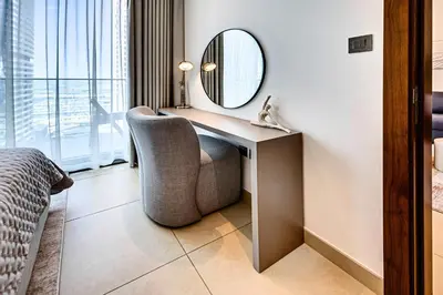 a bedroom with a desk with a chair and a mirror at Brand new 1 bedroom in Marina gate 2, Dubai Marina in Dubai