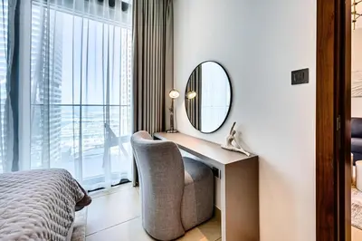 a bedroom with a desk with a mirror and a chair at Brand new 1 bedroom in Marina gate 2, Dubai Marina in Dubai