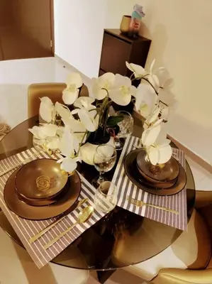a table with plates and glasses and flowers on it at Luxury 1BR Majestine Apartment in Dubai