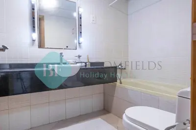 a bathroom with a sink and a toilet and a tub at Bloomfields Stu Lago With Vista Sea View in Dubai