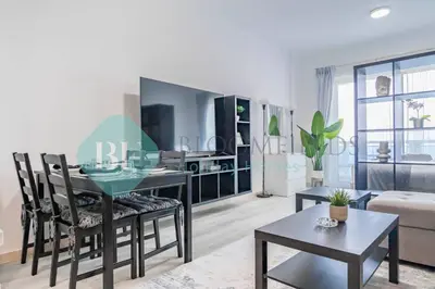 a living room with a table and chairs and a couch at Bloomfields Stu Lago With Vista Sea View in Dubai