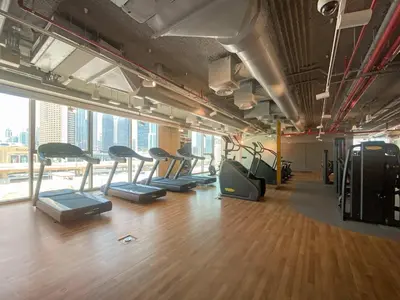 a gym with a row of treadmills in a room at Silkhaus Full Burj Khalifa Views in Downtown in Dubai