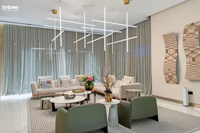 a living room with chairs and tables and a chandelier at bnbmehomes - Urban Oasis by Missoni in Dubai