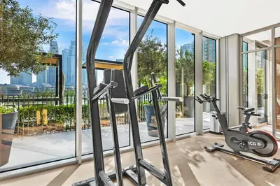 a gym with two exercise bikes in a building with windows at FIRST CLASS 1BR Heart of Tranquility in Dubai