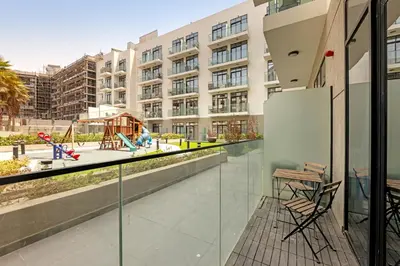an apartment balcony with chairs and a playground at Comfy JVC Studio Pantheon Comfort & Style by Vibel in Dubai