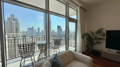 a living room with a couch and a balcony with a view at Guest Favorite - Modern 3BR High Views Prime Location at Downtown in Dubai