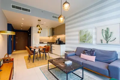a living room with a blue couch and a table at Stunning Marina Waterfront 2 Bed Escape in Dubai