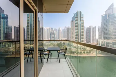 a balcony with tables and chairs and a view of the city at Stunning Marina Waterfront 2 Bed Escape in Dubai
