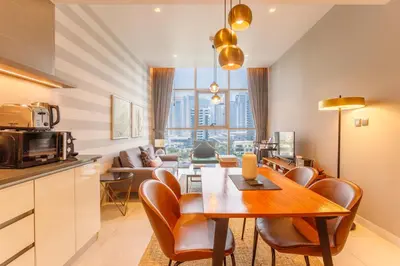 a kitchen and living room with a table and chairs at Stunning Marina Waterfront 2 Bed Escape in Dubai