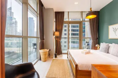 a hotel room with a bed and a large window at Stunning Marina Waterfront 2 Bed Escape in Dubai