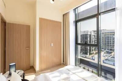 a bedroom with a large window with a view of a city at Trendy Azizi Riviera 1-Bed with Balcony Views in Dubai