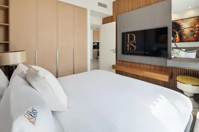a bedroom with a white bed and a tv at Community view home-Dubai Creek Harbour - By DuStay in Dubai