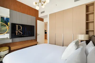 a bedroom with a bed and a tv on a wall at Luxurious Apartment, Dubai Creek Harbour - By Dustay in Dubai