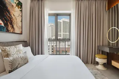 a bedroom with a large bed and a large window at Dubai Creek Poolside view Apartment - By DuStay in Dubai