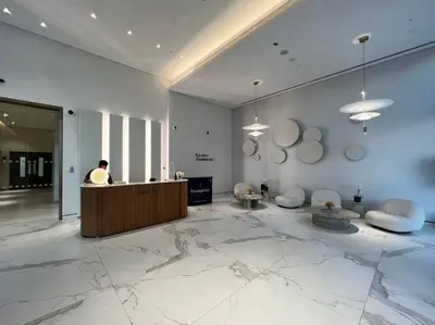 a lobby with a person sitting at a counter at FIRST CLASS 1BR Stunning Marina & Palm View in Dubai