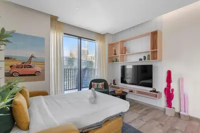 a room with a bed and a tv and a living room at Stunning 1 bedroom Apartment w Burj Khalifa View in Dubai
