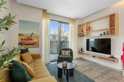a living room with a couch and a tv at Stunning 1 bedroom Apartment w Burj Khalifa View in Dubai