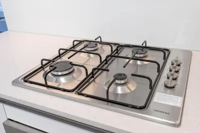 a stove top with four burners on a kitchen counter at New Charming Studio in JVC in Dubai