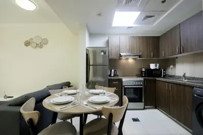 a kitchen and dining room with a table and chairs at Livbnb-Spacious JVC Studio, Near Dining and Shops in Dubai