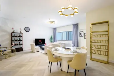 a living room with a white table and chairs at Livbnb Suites - Burj Khalifa View 2BR spacious apt in Dubai
