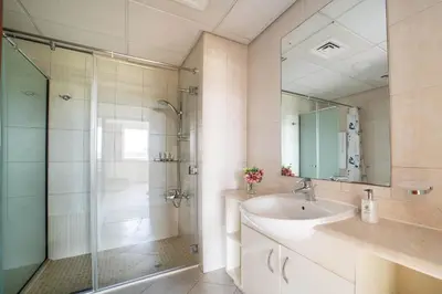 a bathroom with a shower and a sink and a mirror at Frank Porter - Widcombe House 3 in Dubai