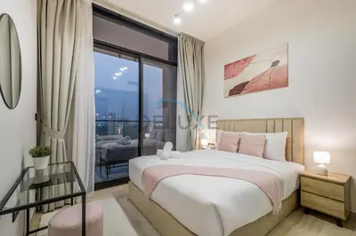 a bedroom with a bed and a large window at Modern 1BR Apartment in Binghatti Luna, Jumeirah Village Circle by Deluxe Holiday Homes in Dubai