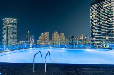 a large swimming pool with a city skyline at night at Livbnb -Glam Studio in Marina Next to Marina Walk in Dubai