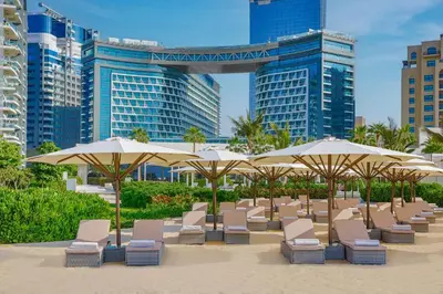 a row of chairs and umbrellas on a beach at Exquisite Studio near Nakheel Mall by Livbnb in Dubai
