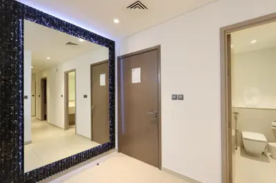 a mirror in a bathroom with a toilet at Livbnb - 3BR Plus 1 with Burj and Fountain Views in Dubai