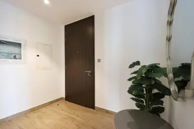 a room with a black door and a plant at 2BR Sunset View Suite -Jumeirah Living Marina Gate in Dubai