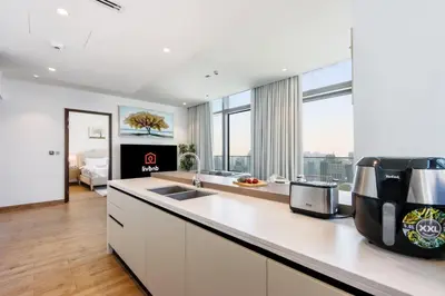 a kitchen with white cabinets and a counter top at 2BR Sunset View Suite -Jumeirah Living Marina Gate in Dubai