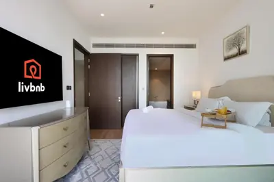 a hotel room with a large bed and a tv at 2BR Sunset View Suite -Jumeirah Living Marina Gate in Dubai