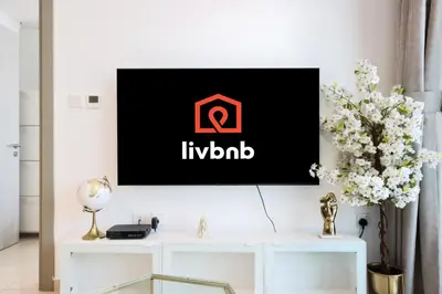 a living room with a tv on a wall at Canalfront Gem 1BR in Zada Tower by Livbnb in Dubai