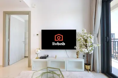 a living room with a tv on a wall at Canalfront Gem 1BR in Zada Tower by Livbnb in Dubai