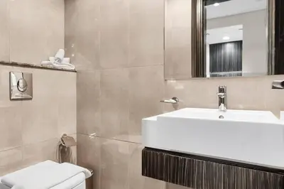 a bathroom with a sink and a toilet and a mirror at Luxury 1BR in Business Bay - Close to Dubai Mall, Burj Khalifa & City Sights in Dubai