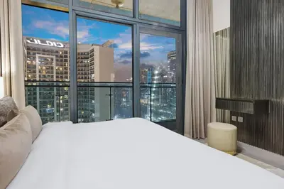 a bedroom with a white bed and a large window at Luxury 1BR in Business Bay - Close to Dubai Mall, Burj Khalifa & City Sights in Dubai