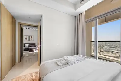 a bedroom with a large bed and a large window at Modern 2-Bedroom Apartment in Aykon Tower C in Dubai