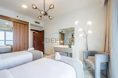a bedroom with two beds and a mirror at Panoramic 2BR Apartment in Princess Tower, Dubai Marina by Deluxe Holiday Homes in Dubai