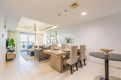 a dining room and living room with a table and chairs at Panoramic 2BR Apartment in Princess Tower, Dubai Marina by Deluxe Holiday Homes in Dubai